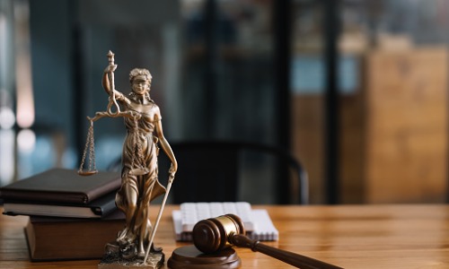 "statue of lady justice on desk of judge or lawyer"