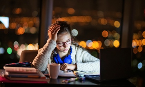 "girl looking frustrated while studying at nighttime"