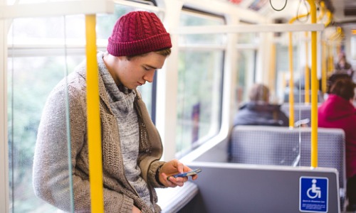 "man using smartphone on bus"