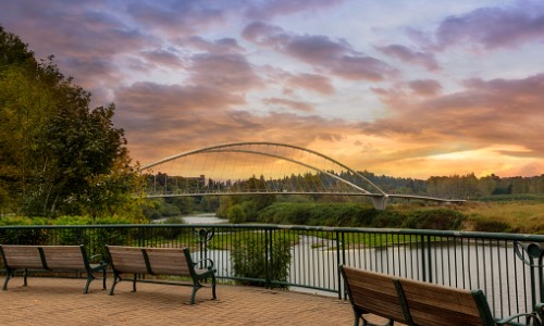 "park benches on riverfront at sunset"