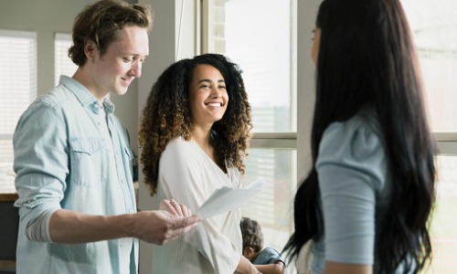 "couple discusses paperwork with woman"