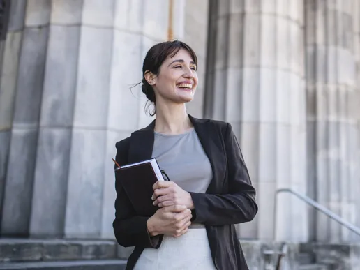 A smiling law student outside a courthouse