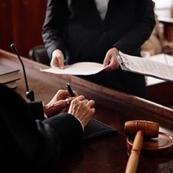 A judge conferring with two people in a courtroom