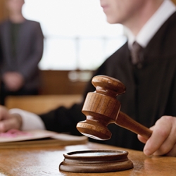 judge holding a gavel in a courtroom