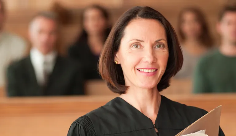 A judge holding papers in her courtroom