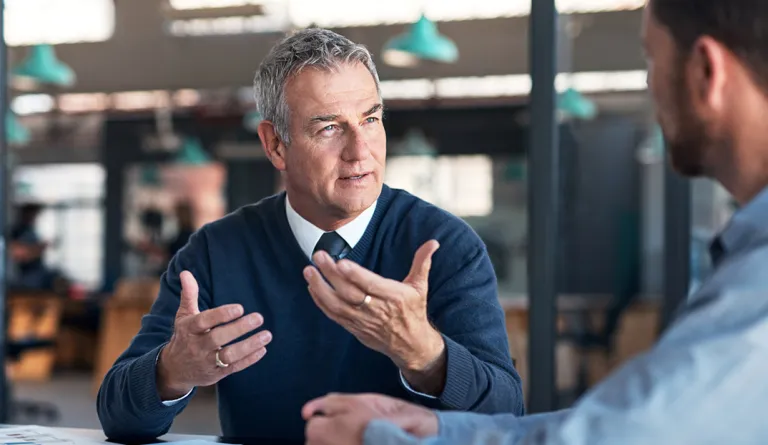 A lawyer talking to a colleague at a table