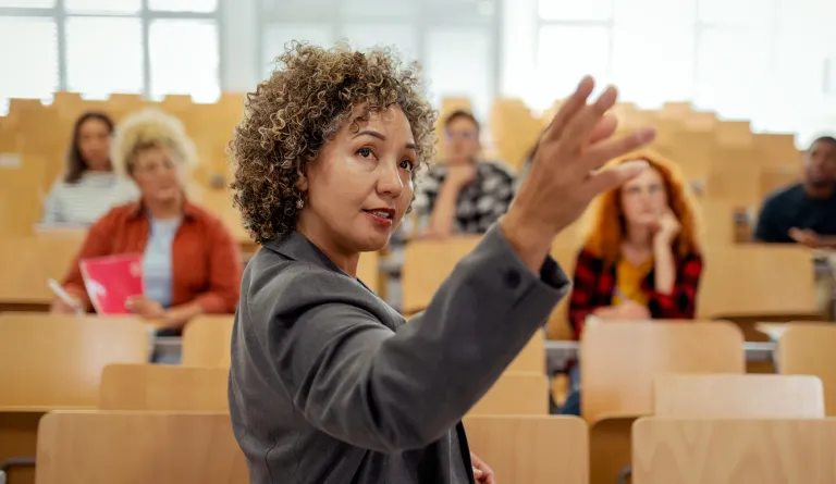 A teacher at the front of a large classroom
