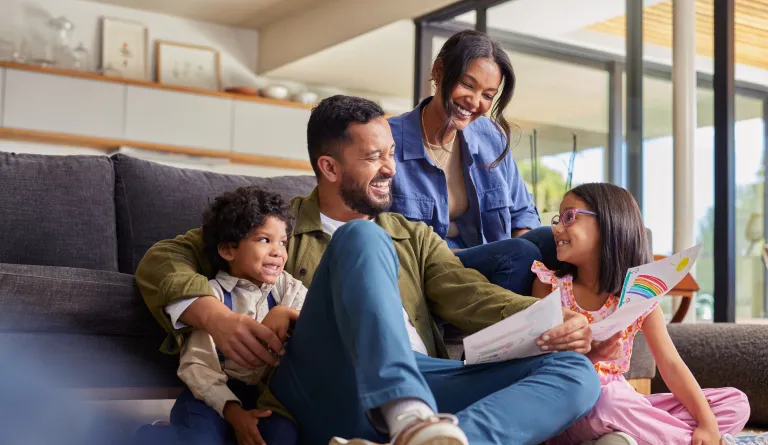 Family of four looks at a child's drawing.