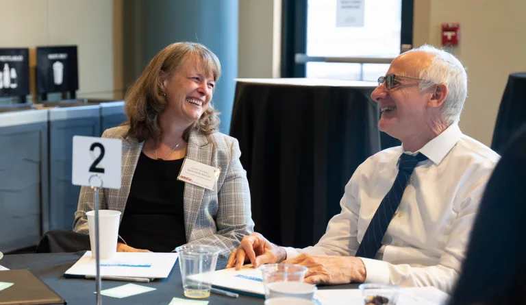 Three people laughing at a conference