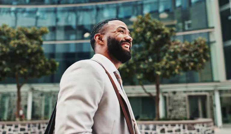 A man smiling as he walks down a street