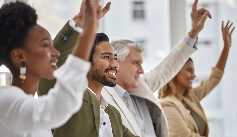 People raising their hands to participate together