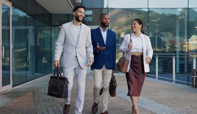 Three people walking in front of a building