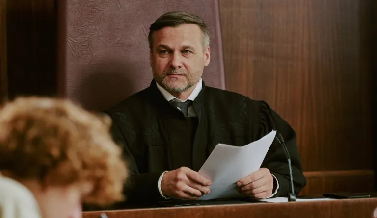 A judge listens to someone in the courtroom.