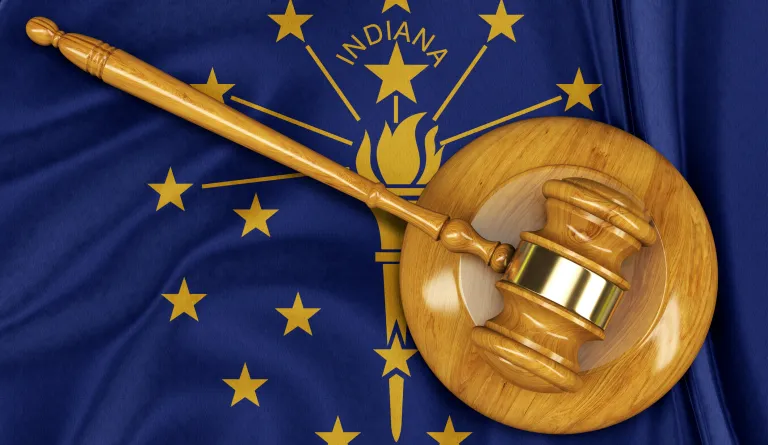 A gavel laying on top of the Indiana state flag
