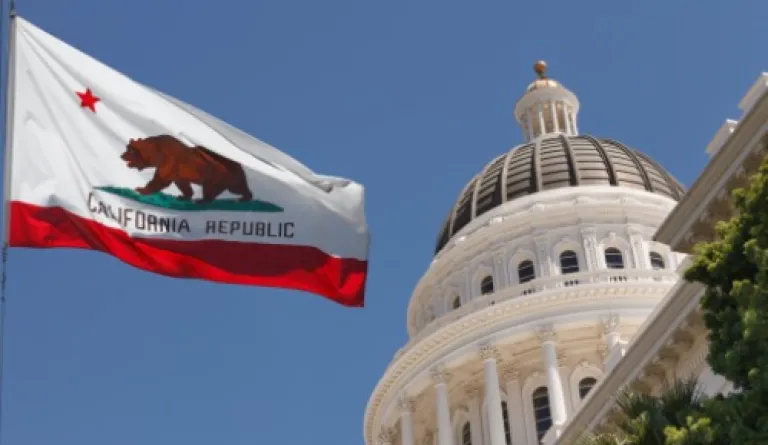 California state capitol building with state flag flying in front
