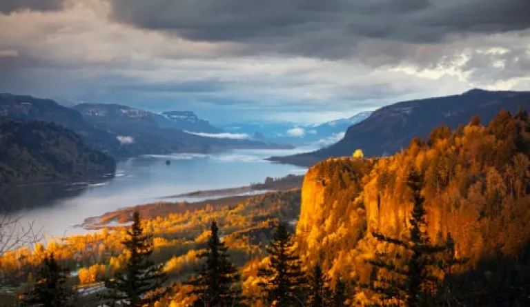 view of river between mountains covered with fall foliage