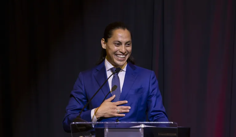 smiling man in blue suit at podium