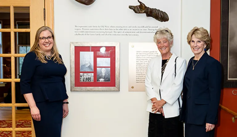 IAALS founders and CEO standing beside new tribute wall