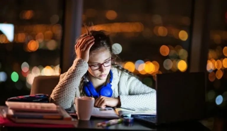 girl looking frustrated while studying at nighttime
