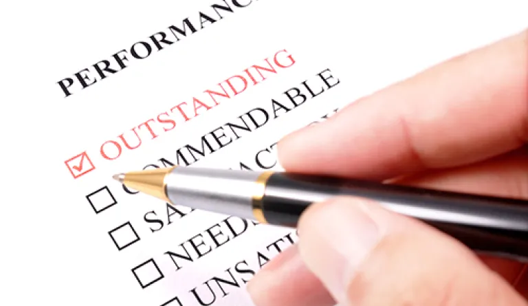 hand holding pen to do performance evaluation