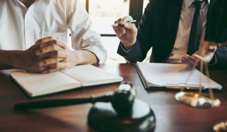 two people sitting at desk with gavel