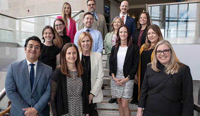 group of smiling people standing on steps