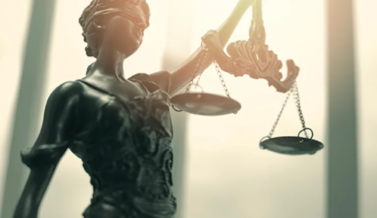 close up of metal lady justice holding scales