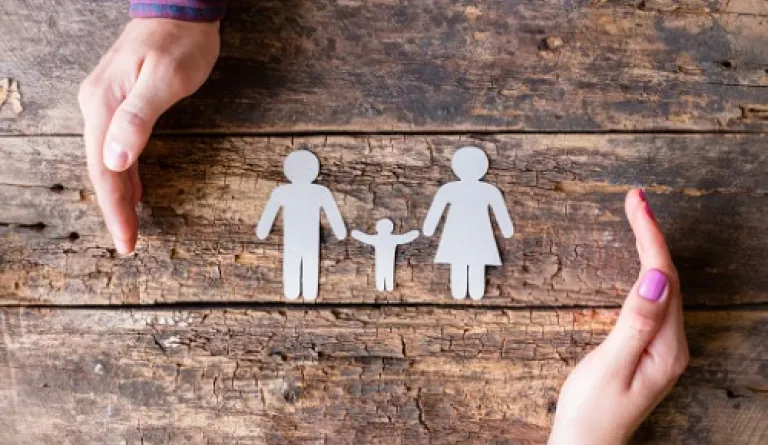 paper cutout of family on wood