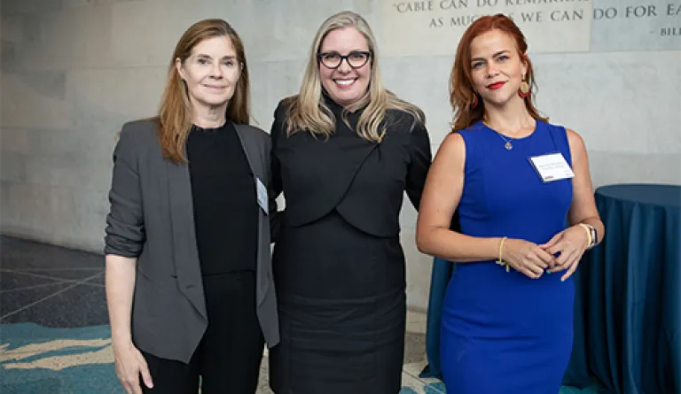 three women standing together and smiling