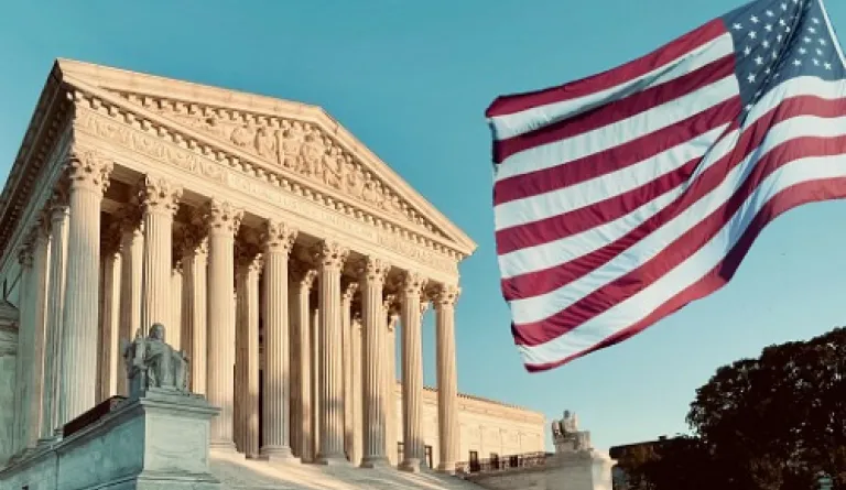 U.S. Supreme Court with American flag flying in foreground