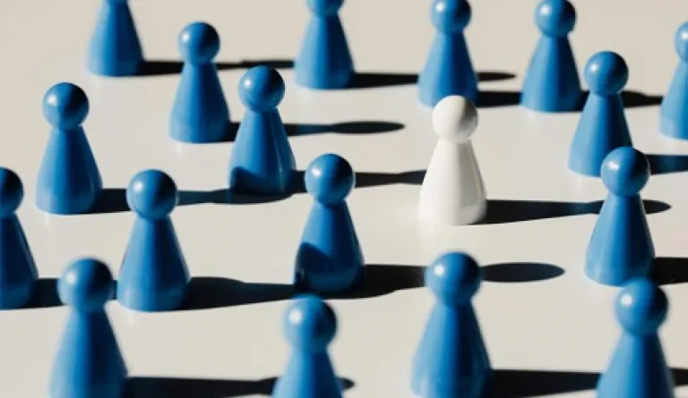 white pawn amid blue pawns