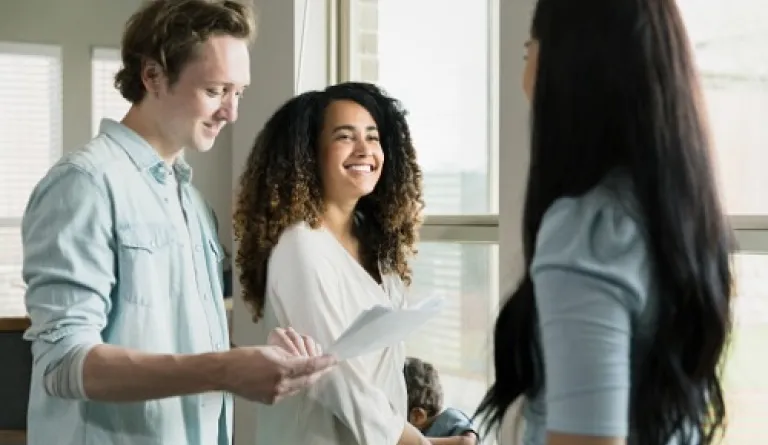 couple discusses paperwork with woman