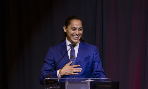 smiling man in blue suit at podium
