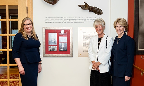 IAALS founders and CEO standing beside new tribute wall