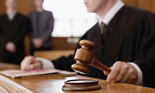 judge holding a gavel in a courtroom