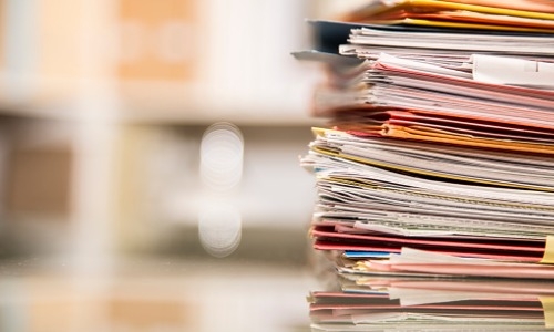 large stack of files on desk