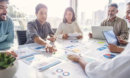 people sitting at a table reviewing data figures together