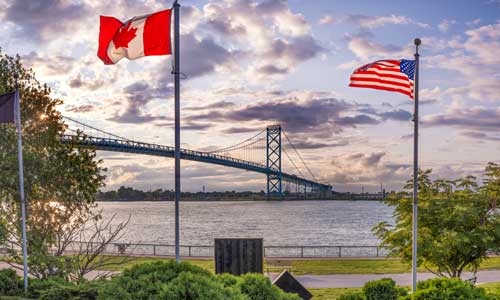 US and Canada flags by a bridge