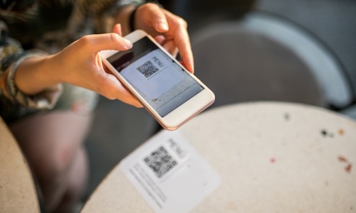 woman scanning QR code with smartphone