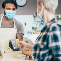 Masked merchant helping customer