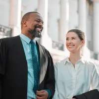 Three people smiling at a courthouse