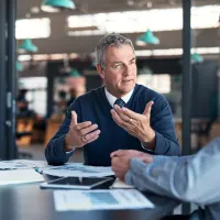 A lawyer talking to a colleague at a table
