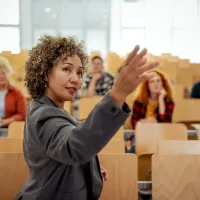 A teacher at the front of a large classroom
