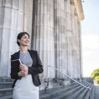 A smiling law student outside a courthouse