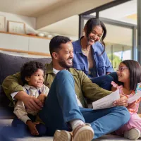 Family of four looks at a child's drawing.