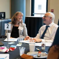 Three people laughing at a conference