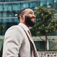A man smiling as he walks down a street