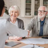 A lawyer helping an elderly couple with paperwork.