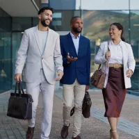 Three people walking in front of a building