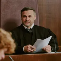 A judge listens to someone in the courtroom.